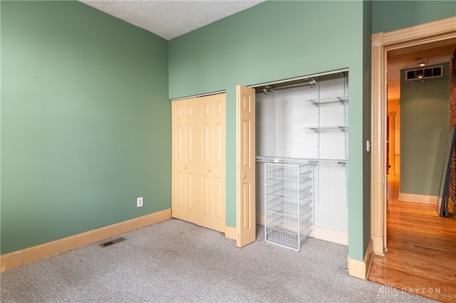 unfurnished bedroom featuring a textured ceiling and carpet