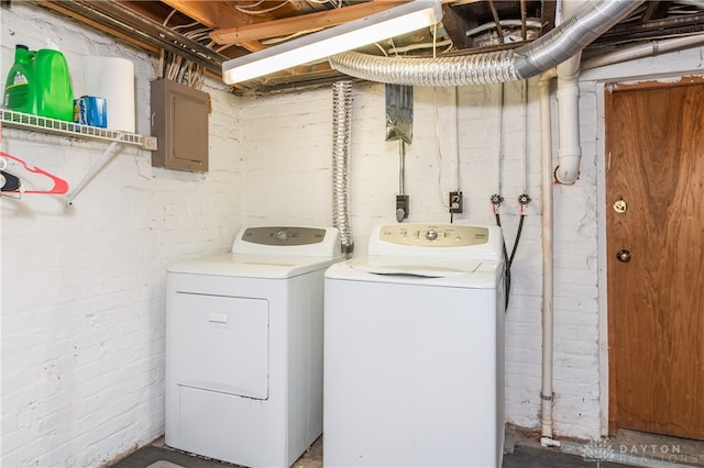 clothes washing area featuring electric panel and separate washer and dryer