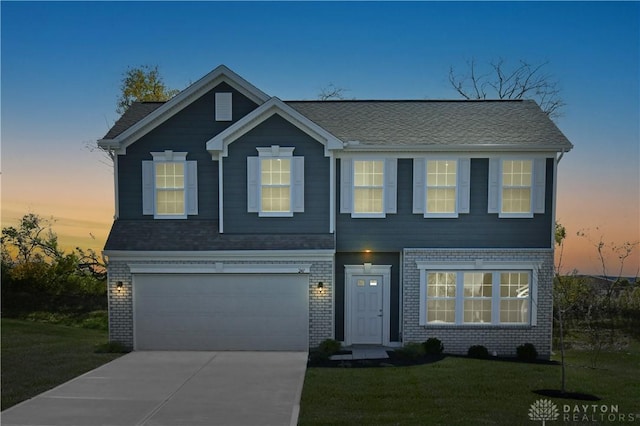 view of front of home featuring concrete driveway, a garage, a lawn, and brick siding