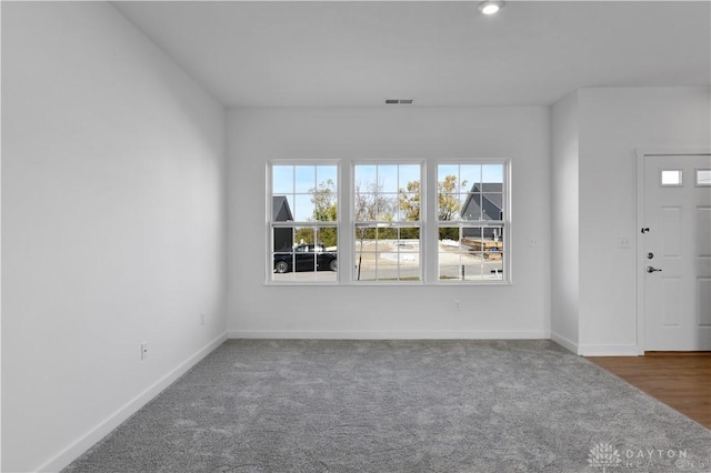 carpeted foyer entrance with visible vents and baseboards