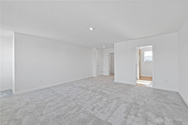 spare room featuring recessed lighting, baseboards, and carpet floors