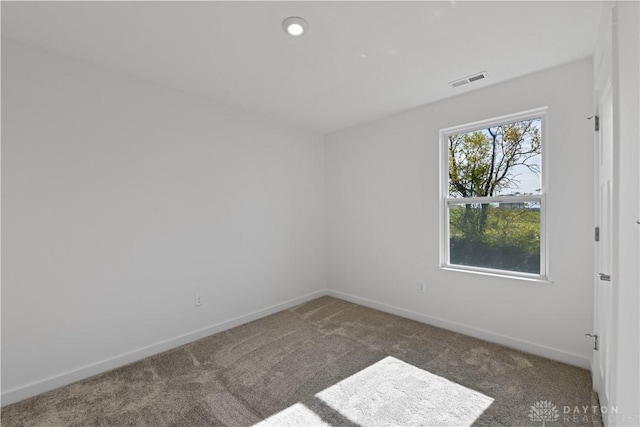 carpeted spare room with baseboards and visible vents