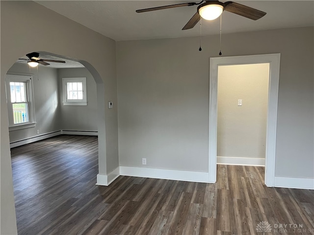 spare room with dark hardwood / wood-style flooring, ceiling fan, and a baseboard heating unit