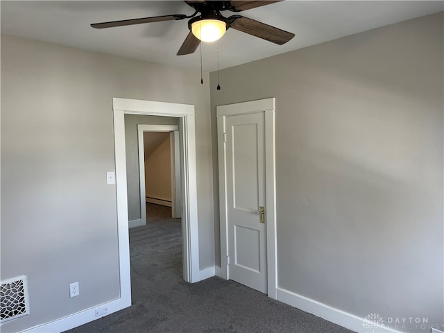 carpeted spare room with ceiling fan and a baseboard radiator