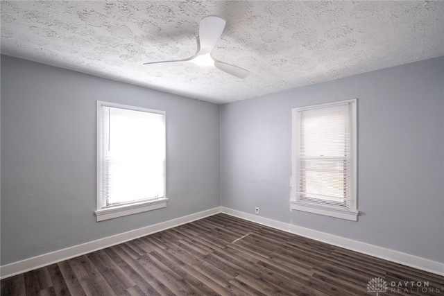 unfurnished room with dark hardwood / wood-style flooring, a textured ceiling, ceiling fan, and plenty of natural light