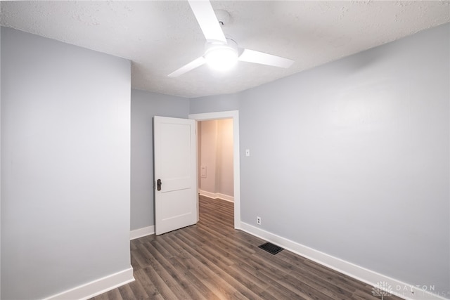 unfurnished room featuring dark wood-type flooring, a textured ceiling, and ceiling fan