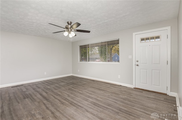 foyer with dark hardwood / wood-style flooring, a textured ceiling, and ceiling fan