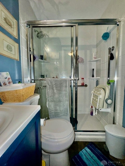 bathroom featuring toilet, an enclosed shower, and vanity