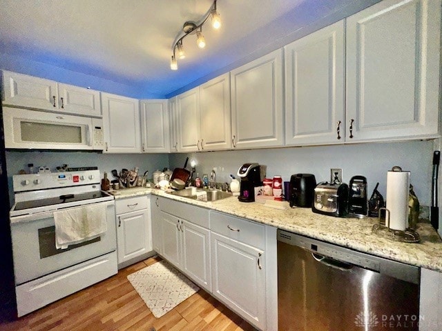 kitchen featuring sink, light stone countertops, white appliances, white cabinets, and light wood-type flooring