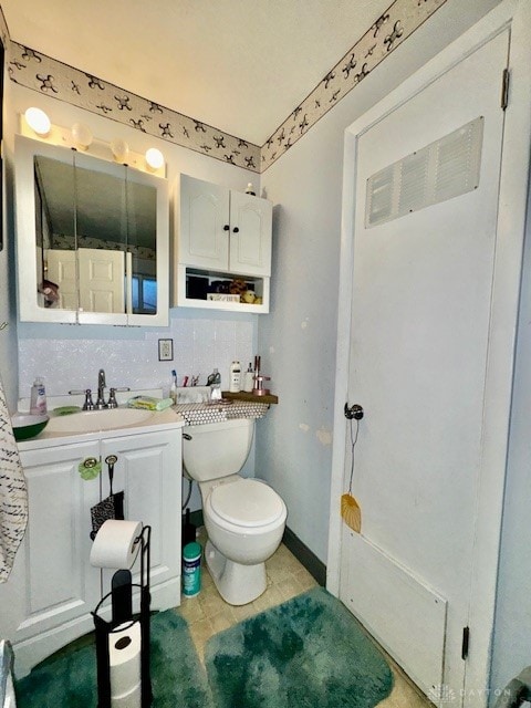 bathroom featuring toilet, tasteful backsplash, and sink