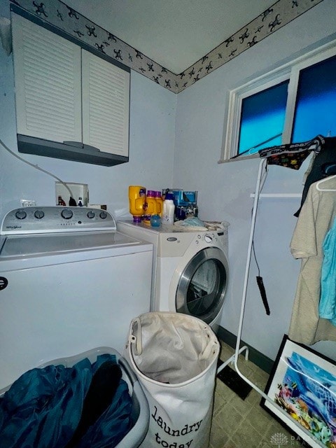 clothes washing area with cabinets and washing machine and clothes dryer