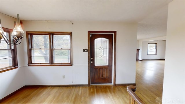 entrance foyer with an inviting chandelier and wood-type flooring