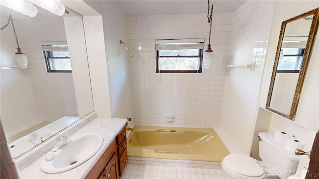 full bathroom featuring vanity, toilet, and tiled shower / bath