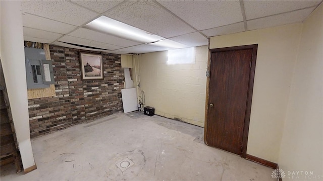 basement with a drop ceiling and electric panel