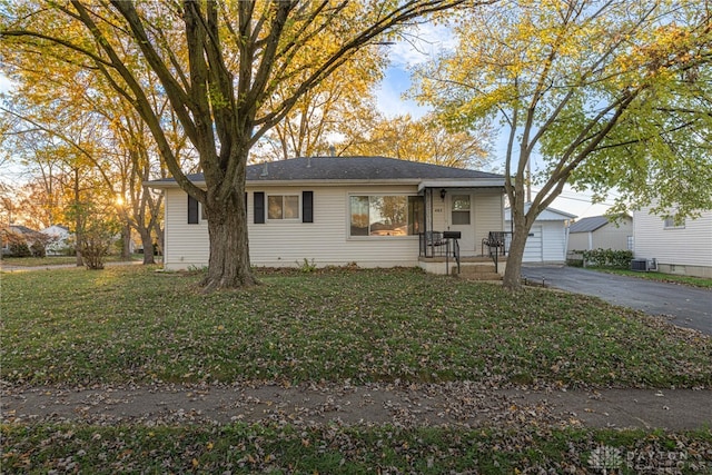 single story home with a garage, an outdoor structure, and a front yard