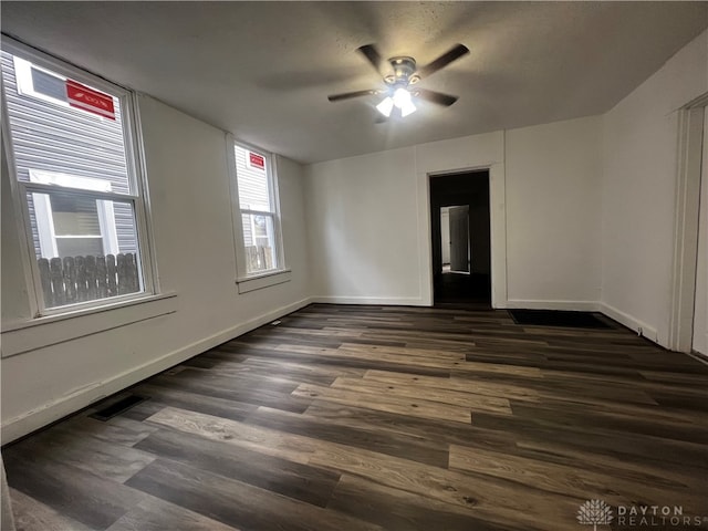 empty room with ceiling fan and dark hardwood / wood-style floors