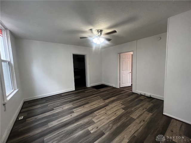 unfurnished room featuring a textured ceiling, dark hardwood / wood-style floors, and ceiling fan