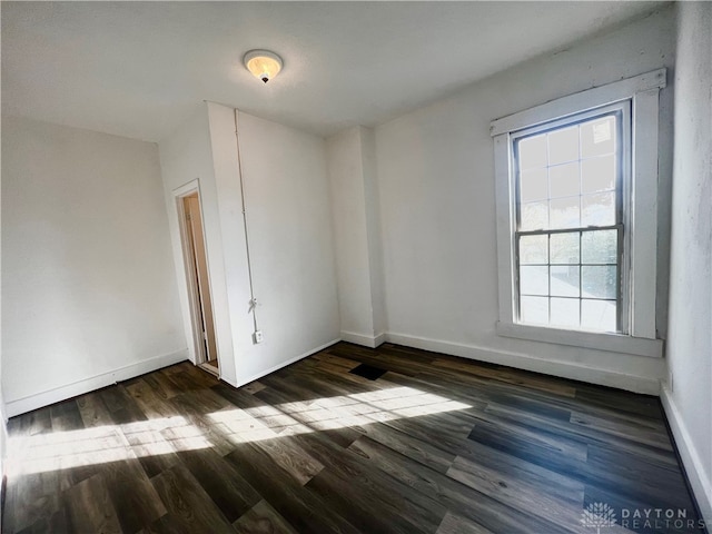 spare room featuring dark wood-type flooring