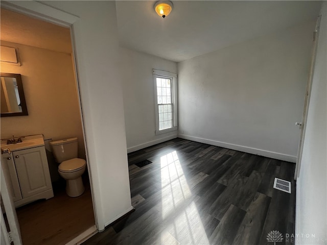 spare room with dark hardwood / wood-style flooring and sink