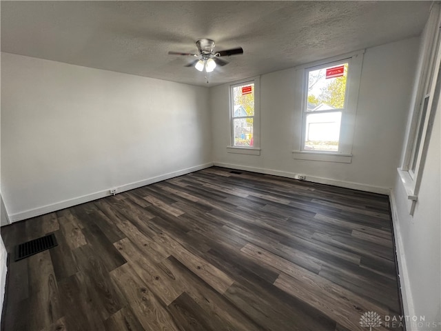 unfurnished room featuring dark wood-type flooring, ceiling fan, and a textured ceiling