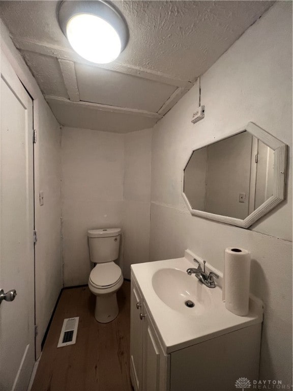 bathroom featuring hardwood / wood-style floors, vanity, and toilet