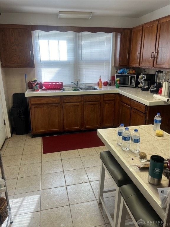 kitchen featuring sink, light tile patterned flooring, and a breakfast bar