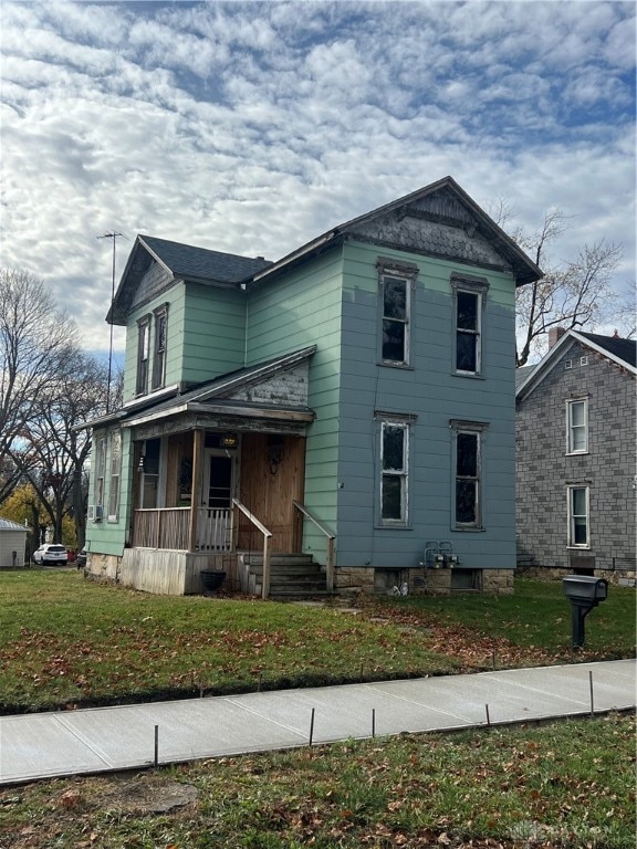 view of front of house with covered porch and a front yard