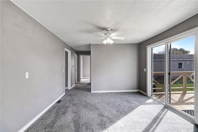 spare room with ceiling fan and dark carpet