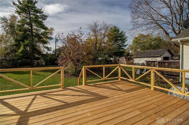 deck with a shed and a yard