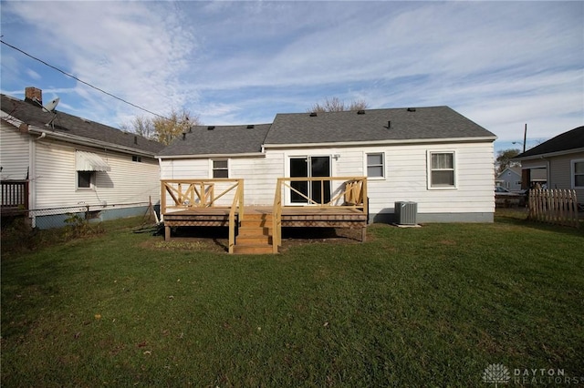 back of house with central AC unit, a wooden deck, and a lawn