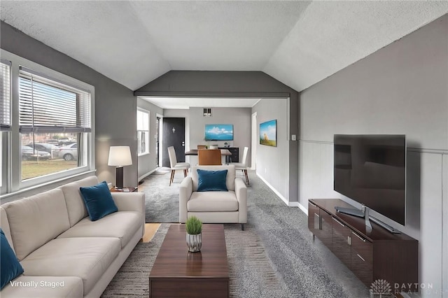 carpeted living room with lofted ceiling