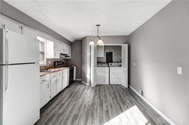 kitchen with white cabinetry, black / electric stove, white fridge, pendant lighting, and washer and dryer