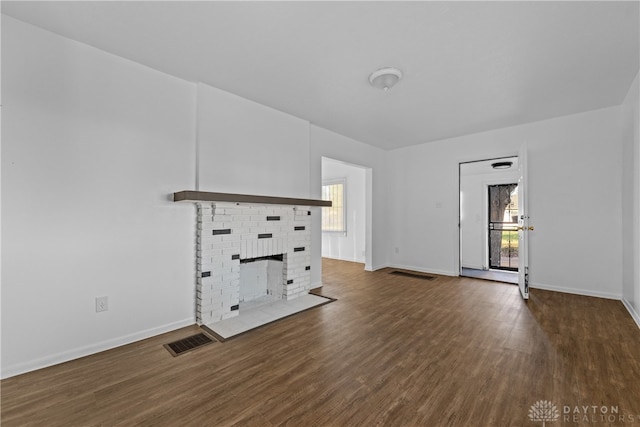 unfurnished living room featuring dark wood-type flooring and a fireplace