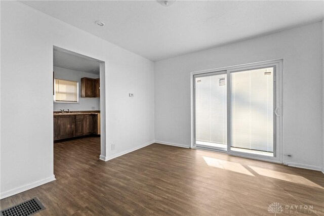 spare room featuring dark wood-type flooring and sink