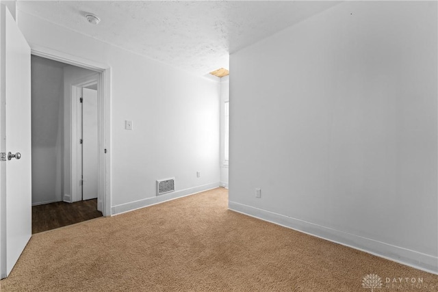 carpeted spare room with a textured ceiling