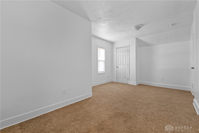 interior space with a textured ceiling and carpet flooring