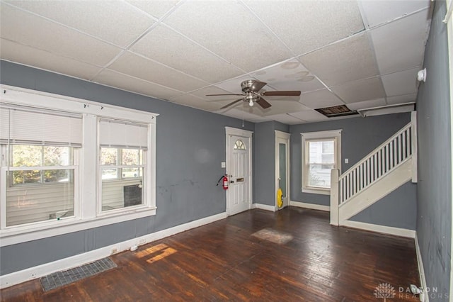 interior space with dark wood-type flooring, a paneled ceiling, and ceiling fan