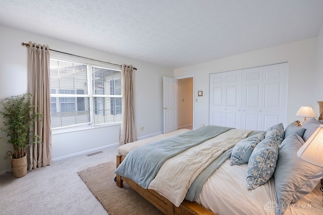 carpeted bedroom featuring a closet and a textured ceiling