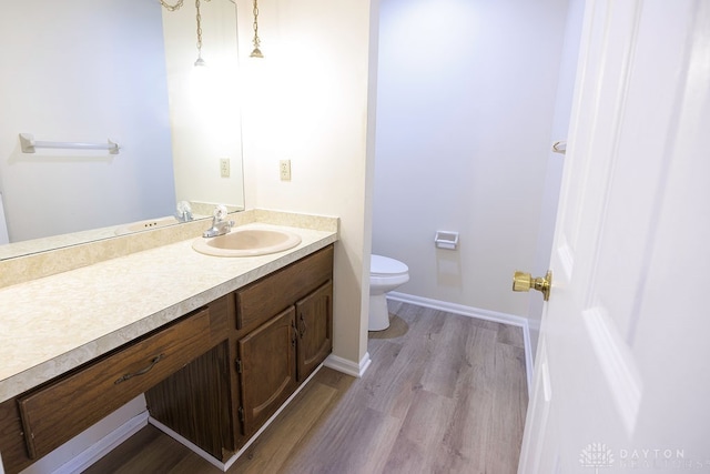 bathroom featuring wood-type flooring, vanity, and toilet