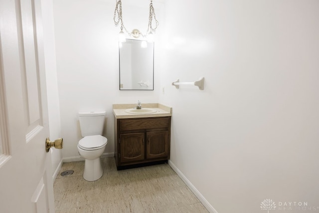 bathroom with vanity, toilet, and a notable chandelier