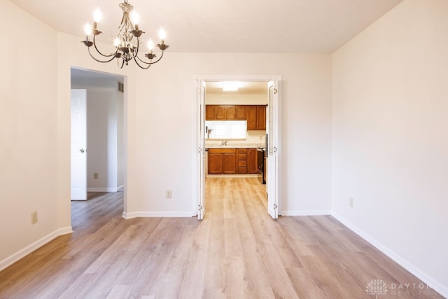 unfurnished dining area with a chandelier and light hardwood / wood-style flooring