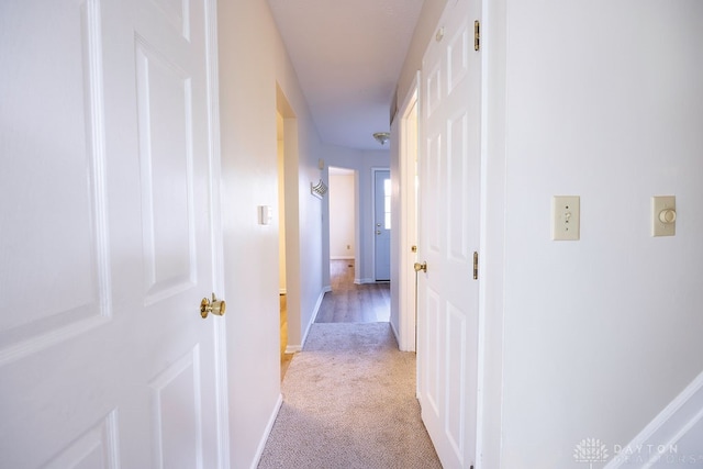 hallway featuring light colored carpet