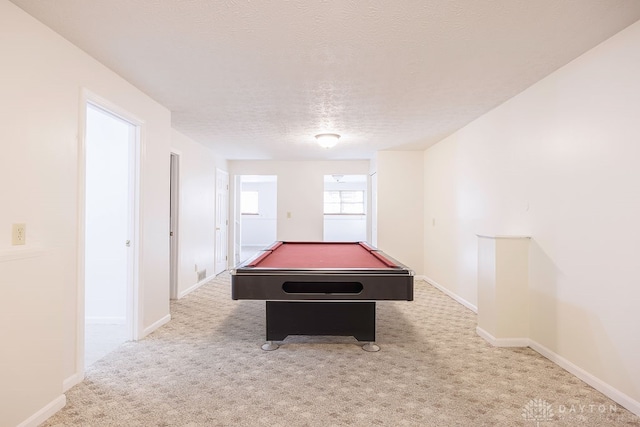 rec room with billiards, light colored carpet, and a textured ceiling