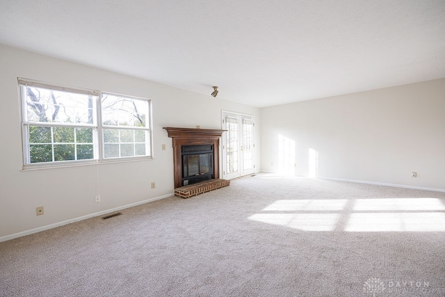 unfurnished living room with a fireplace and light colored carpet