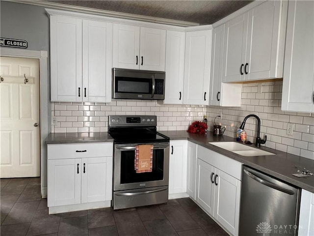 kitchen with white cabinets, appliances with stainless steel finishes, backsplash, and sink