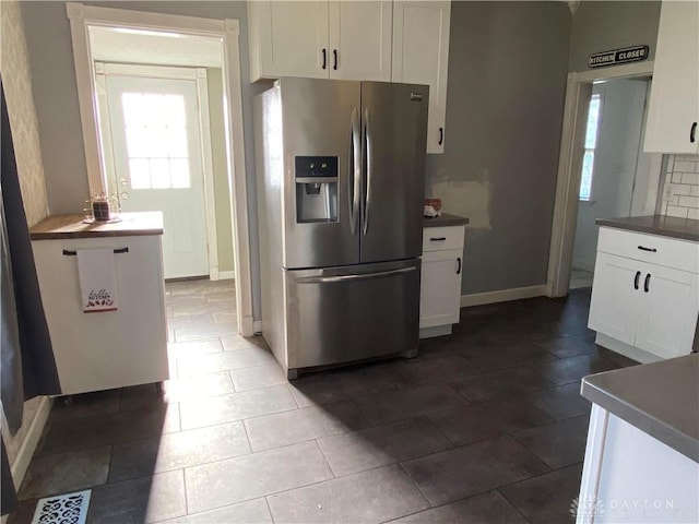 kitchen with decorative backsplash, stainless steel fridge with ice dispenser, and white cabinets