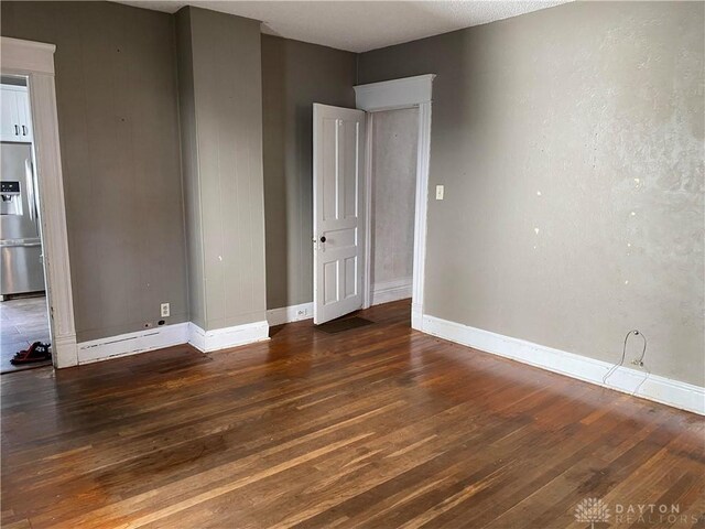 unfurnished room with dark hardwood / wood-style floors