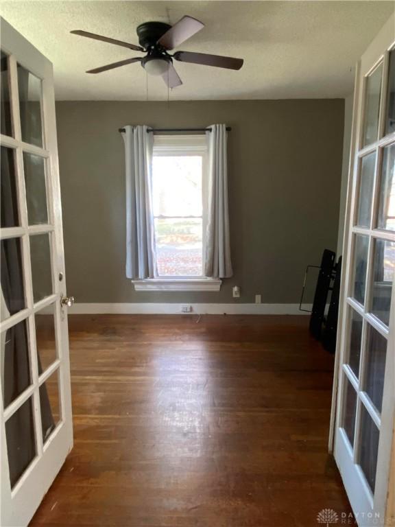 spare room featuring ceiling fan, dark hardwood / wood-style floors, and french doors