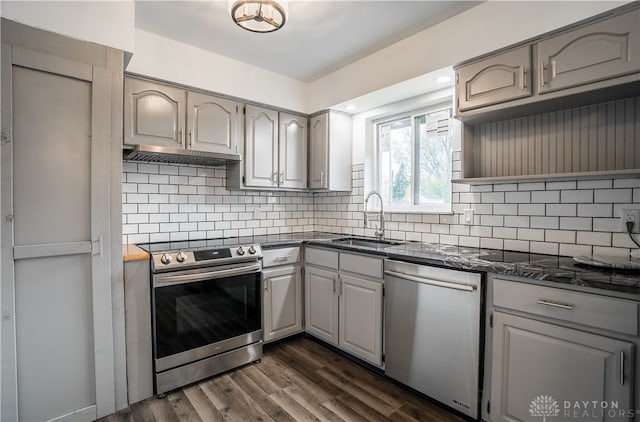 kitchen with appliances with stainless steel finishes, dark hardwood / wood-style flooring, tasteful backsplash, sink, and gray cabinets