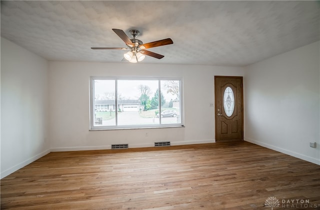 entryway featuring ceiling fan, light hardwood / wood-style floors, and a textured ceiling